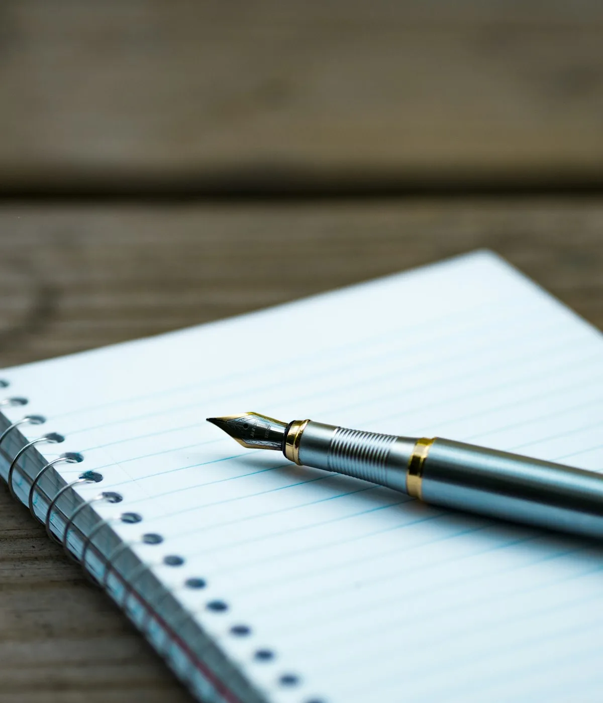 A fountain pen resting on a leather notebook